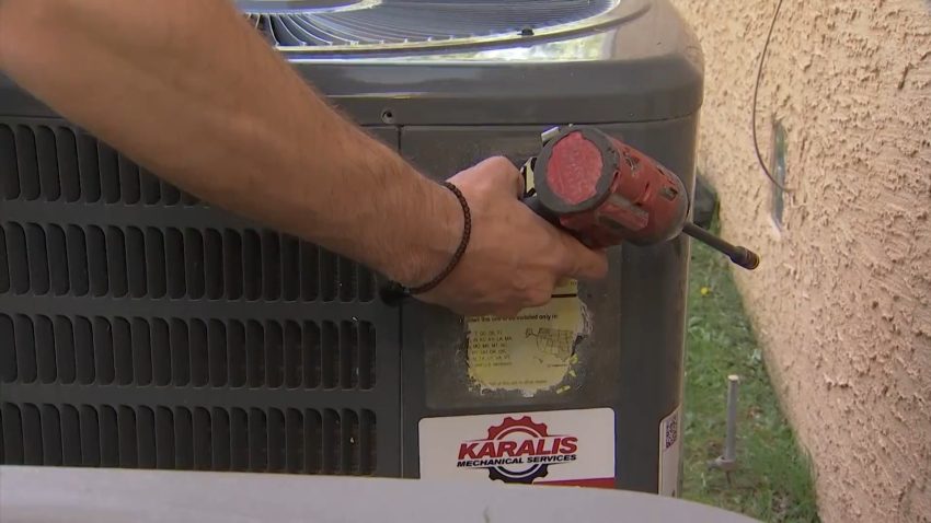 Image of a person working on an air conditioning unit.