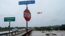 A helicopter flies over the Guadalupe River as floods pass through the area on Thursday, July 16, 2026, in Kerrville, Texas. (AP Photo/Joel Angel Juarez)