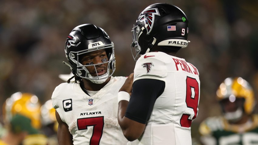Bijan Robinson #7 of the Atlanta Falcons talks with Michael Penix Jr. #9.